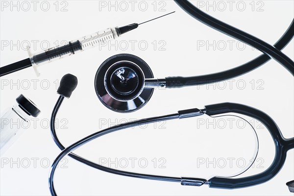 Stethoscope, syringe and test tube on white background.