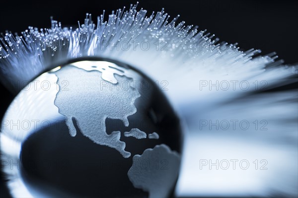 Illustration of fiber optics over globe.