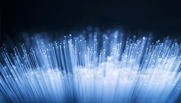 Bunch of glowing fiber optic cables on black background.