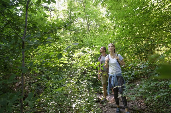 Couple standing in woodlands.