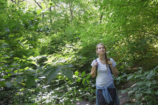Young woman standing in woodlands.
