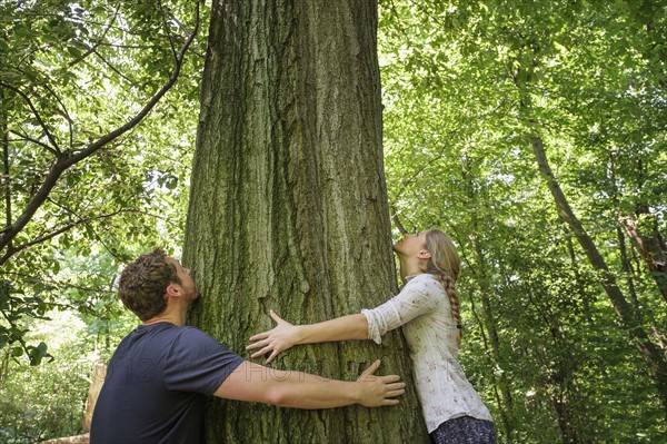 Couple hugging tree.