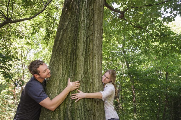 Couple hugging tree.