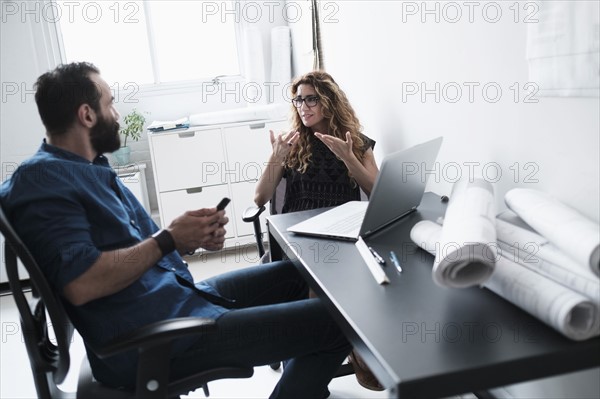 Man and woman talking in office.