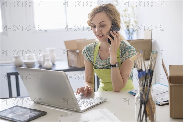 Woman sitting at desk using mobile phone.