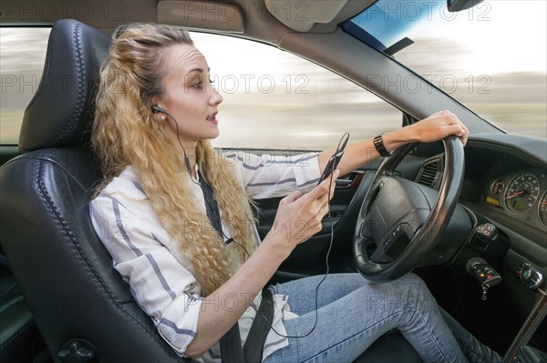 Woman using mobile phone during driving car.