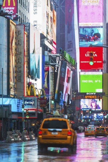 New York City, Car driving through street illuminated by neon lights