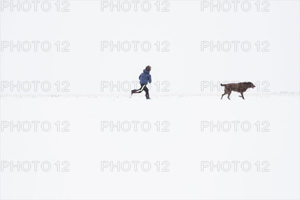 Boy (6-7) running with dog