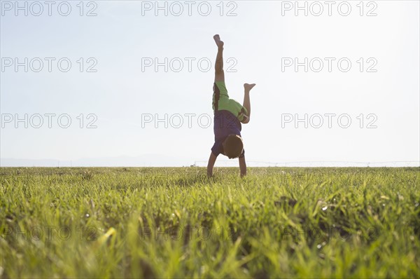 Boy (6-7) standing on hands