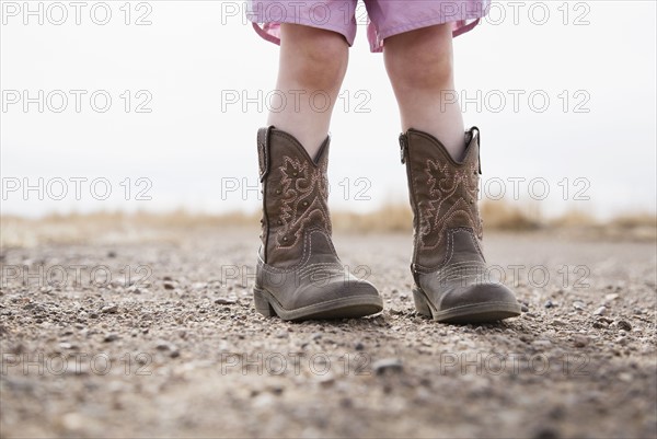 Low section of baby girl (18-23 months) wearing cowboy boots
