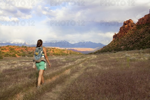 Woman with backpack walking in grass