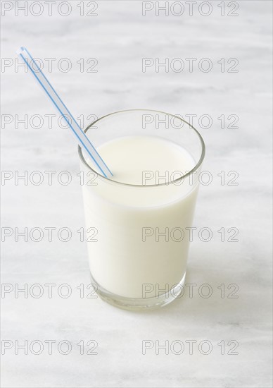 Glass of milk with drinking straw