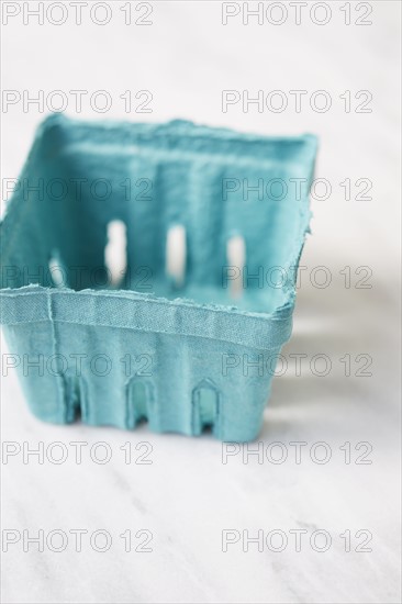 Empty blue fruit carton on marble table