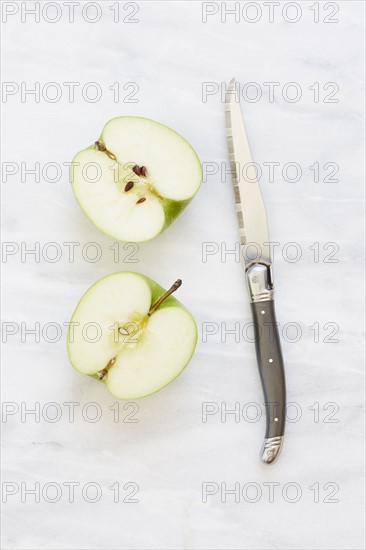 Overhead view of halved apple and knife