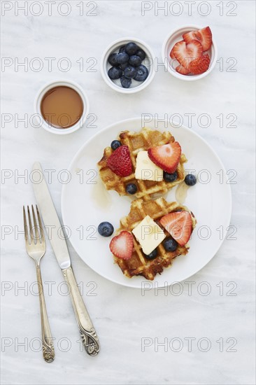 Overhead view of waffles with strawberries and blueberries