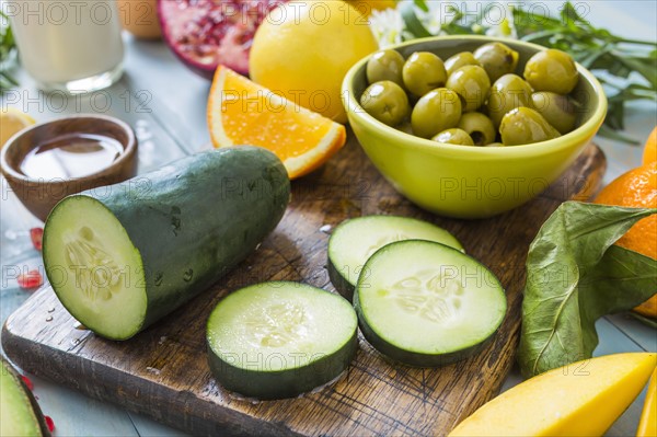 Fresh slices of cucumber and bowl of olives