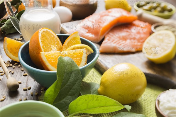 Slices of orange in bowl and salmon fillet