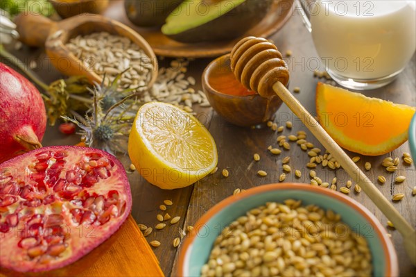 Wheat seeds, honey with dipper and fresh fruits