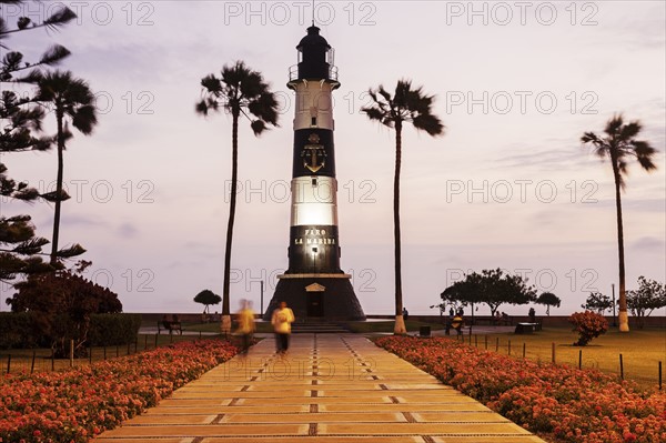 Peru, Lima, Miraflores, Faro De La Marina and palm trees at sunset