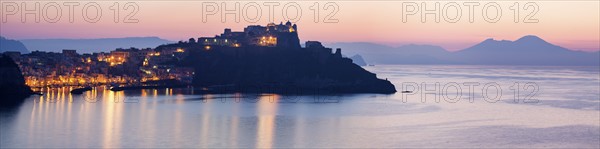 Italy, Campania, Panorama of Procida Island with Mt Vesuvius at sunrise