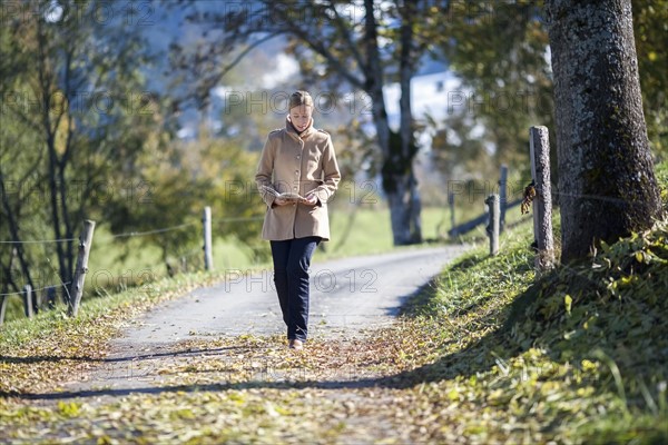 Austria, Salzburger Land, Maria Alm, Mature woman walking on autumn alley