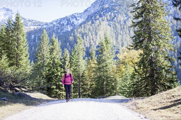 Austria, Salzburger Land, Weissbach, Mature woman hiking on sunny day in mountain landscape