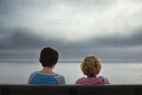 Massachusetts, Cape Cod, Truro, Rear view of two women sitting on bench and looking at sea