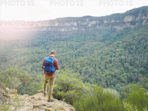 Australia, New South Wales, Katoomba, Rear view of mid adult man looking at Blue Mountains