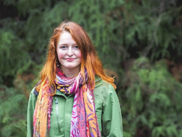 Portrait of smiling redhead in scarf and green jacket