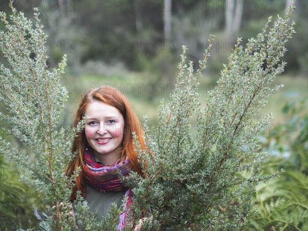 Portrait of smiling redhead in bushes