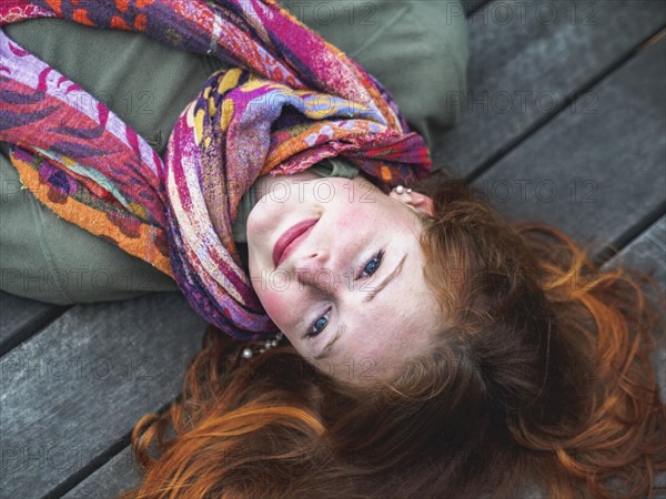 Portrait of smiling redhead lying down