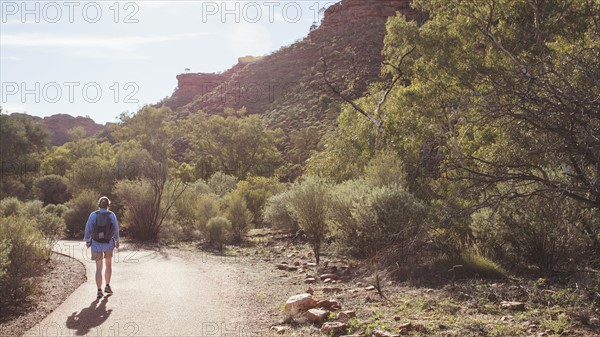 Australia, Outback, Northern Territory, Red Centre, West Macdonnel Ranges, Kings Canyon, Woman walking down mountain road