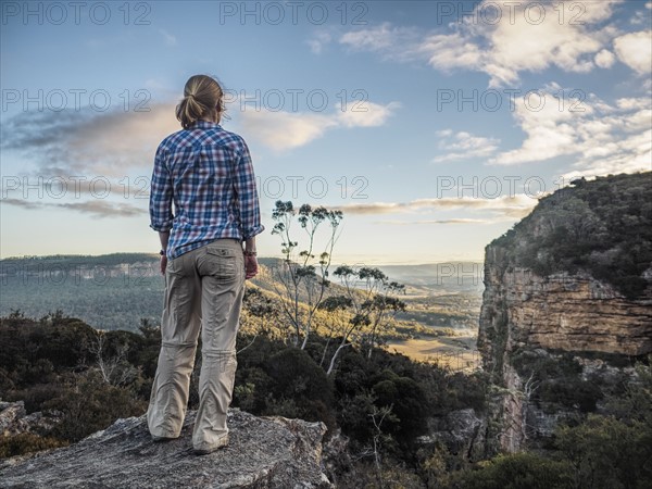 Australia, New South Wales, Blue Mountains, Blackheath, Megalong Valley, Mature woman standing on rock and looking at valley below