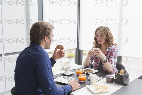 Mid-adult couple eating breakfast