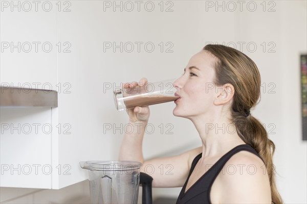 Mid-adult woman drinking smoothie