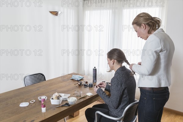 Woman styling other woman's hair