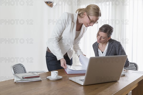 Businesswomen looking at documents at office