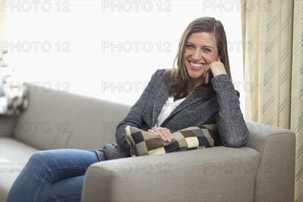 Smiling woman sitting on sofa