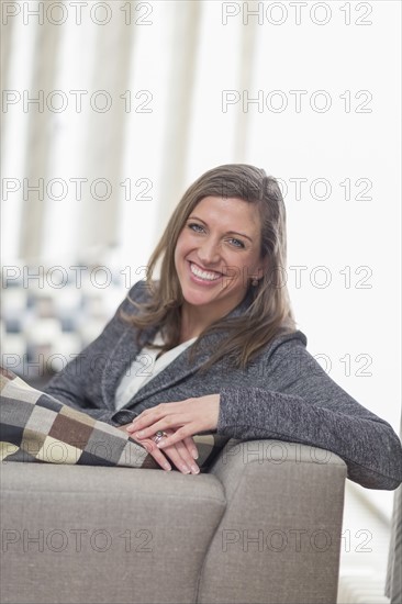 Smiling woman sitting on sofa