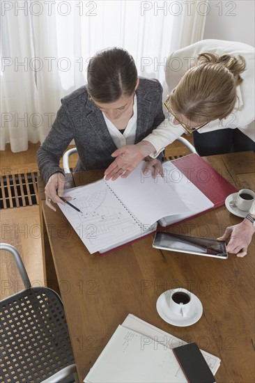 Businesswomen working with tablet and documents