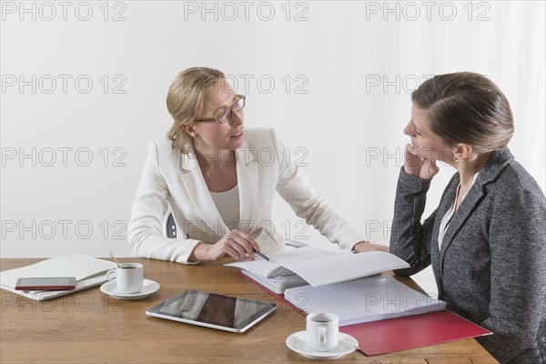 Businesswomen analyzing documents at office