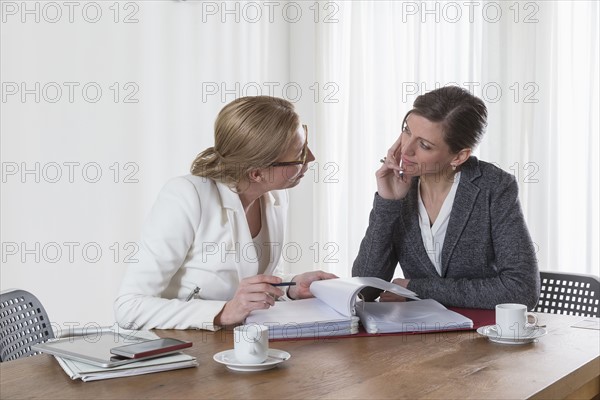 Businesswomen analyzing documents at office