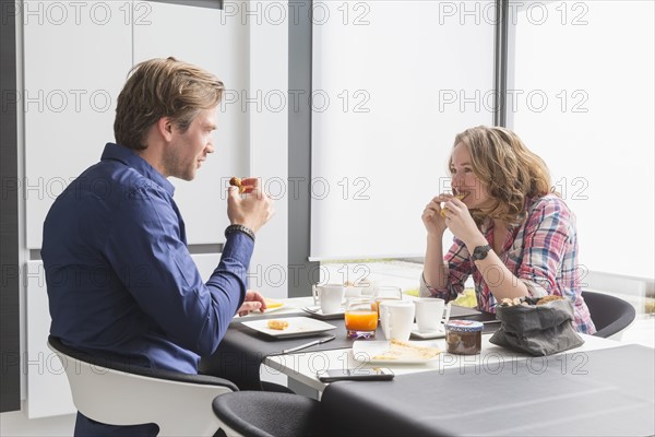 Mid-adult couple eating breakfast