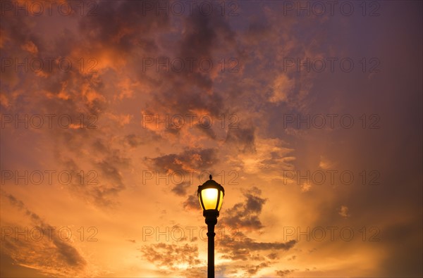 Dramatic sunset sky with lamp post in foreground.