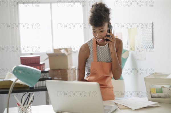 Young woman in home office on the phone.