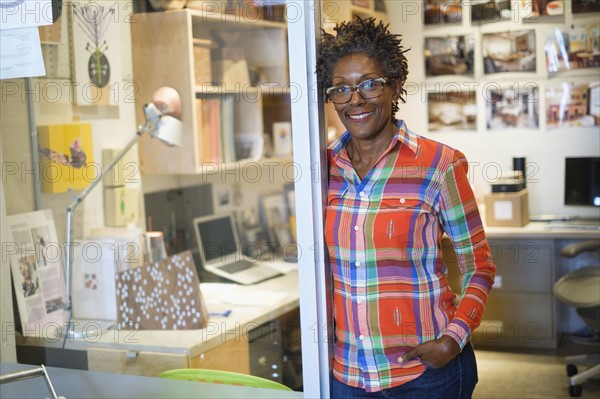 Cheerful woman standing in office.