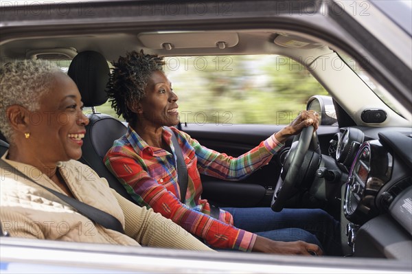 Two smiling women in car.