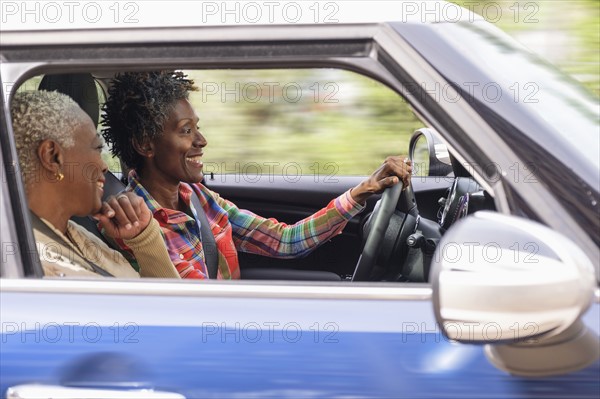 Two smiling women in car.