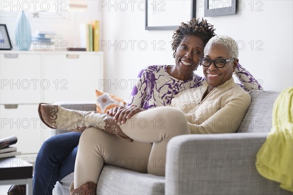 Portrait of smiling women sitting in living room.