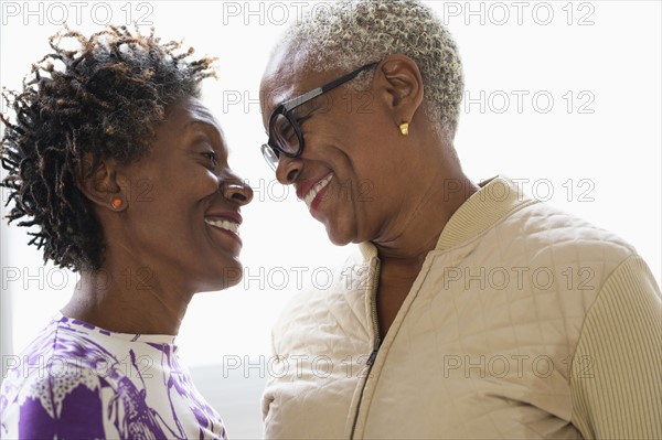 Smiling women looking into eyes.